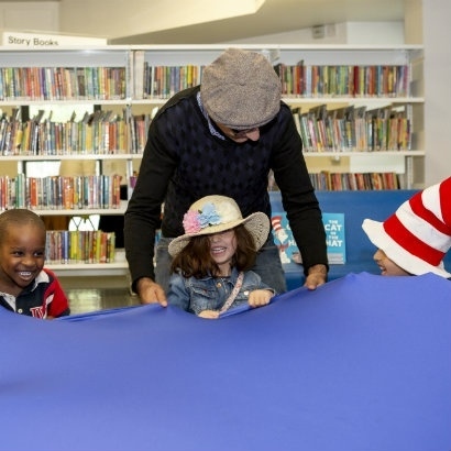 Children holding on to a parachute as part of story time