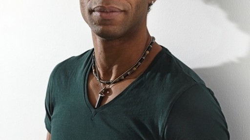 Cuban ballet dancer and author Carlos Acosta showing off his fine physique in a bottle green tee-shirt.