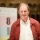 Image of author Michael Morpurgo standing and smiling on stage at MLF 18